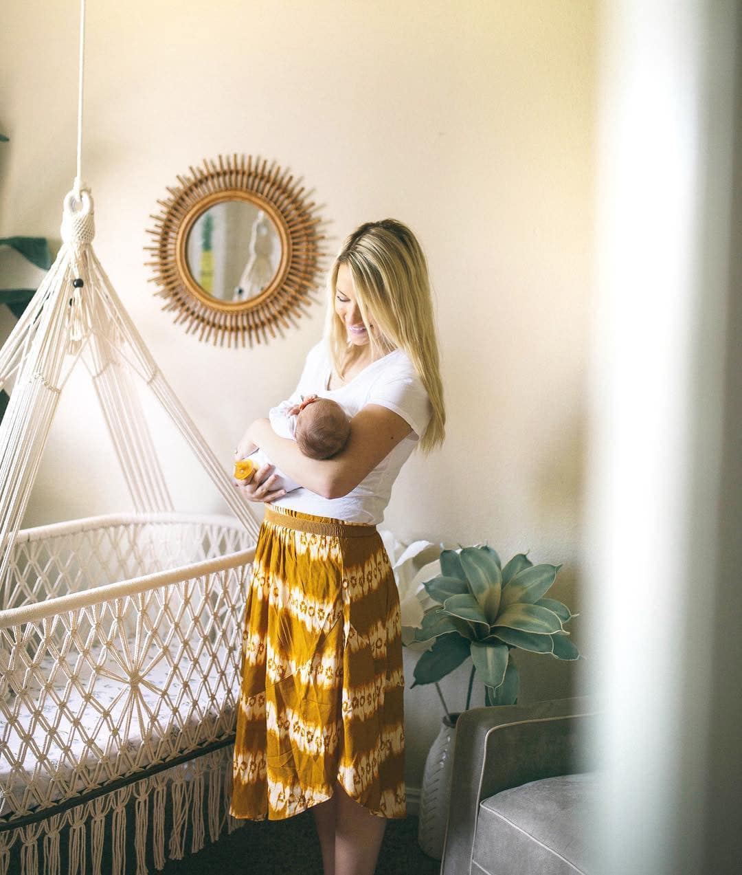 mother and newborn next to a hanging bassinet