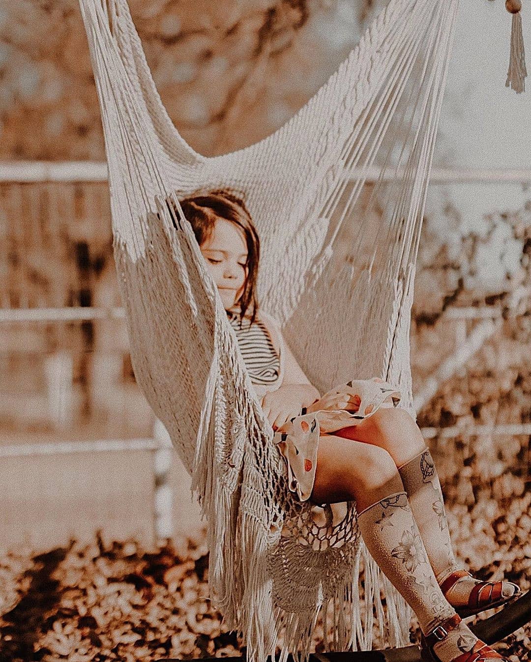 children sitting on a hammock chair