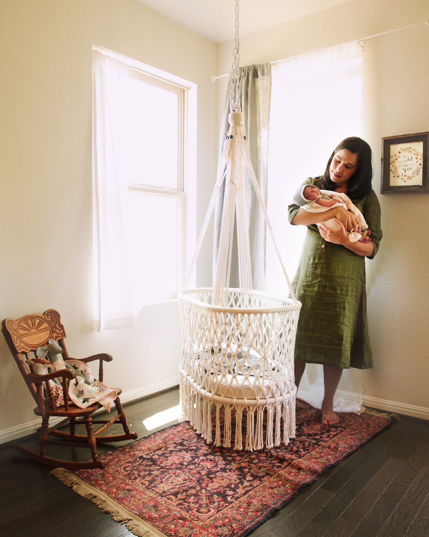 newborn with mother and a hanging cradle