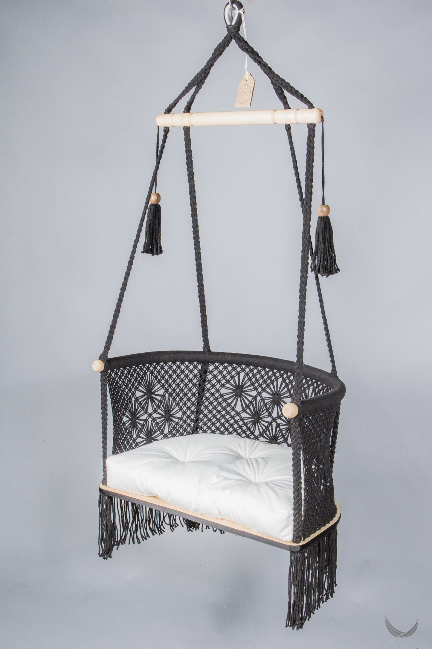 black color hanging chair with a ivory color cushion