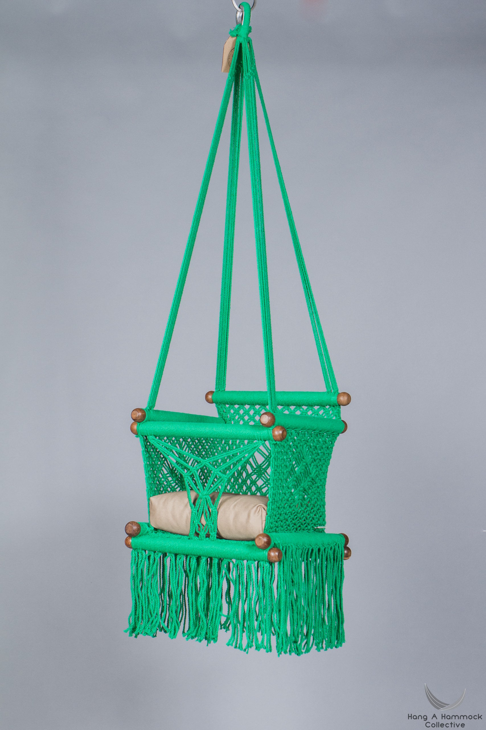 swing chair in green - khaki cushion - studio picture
