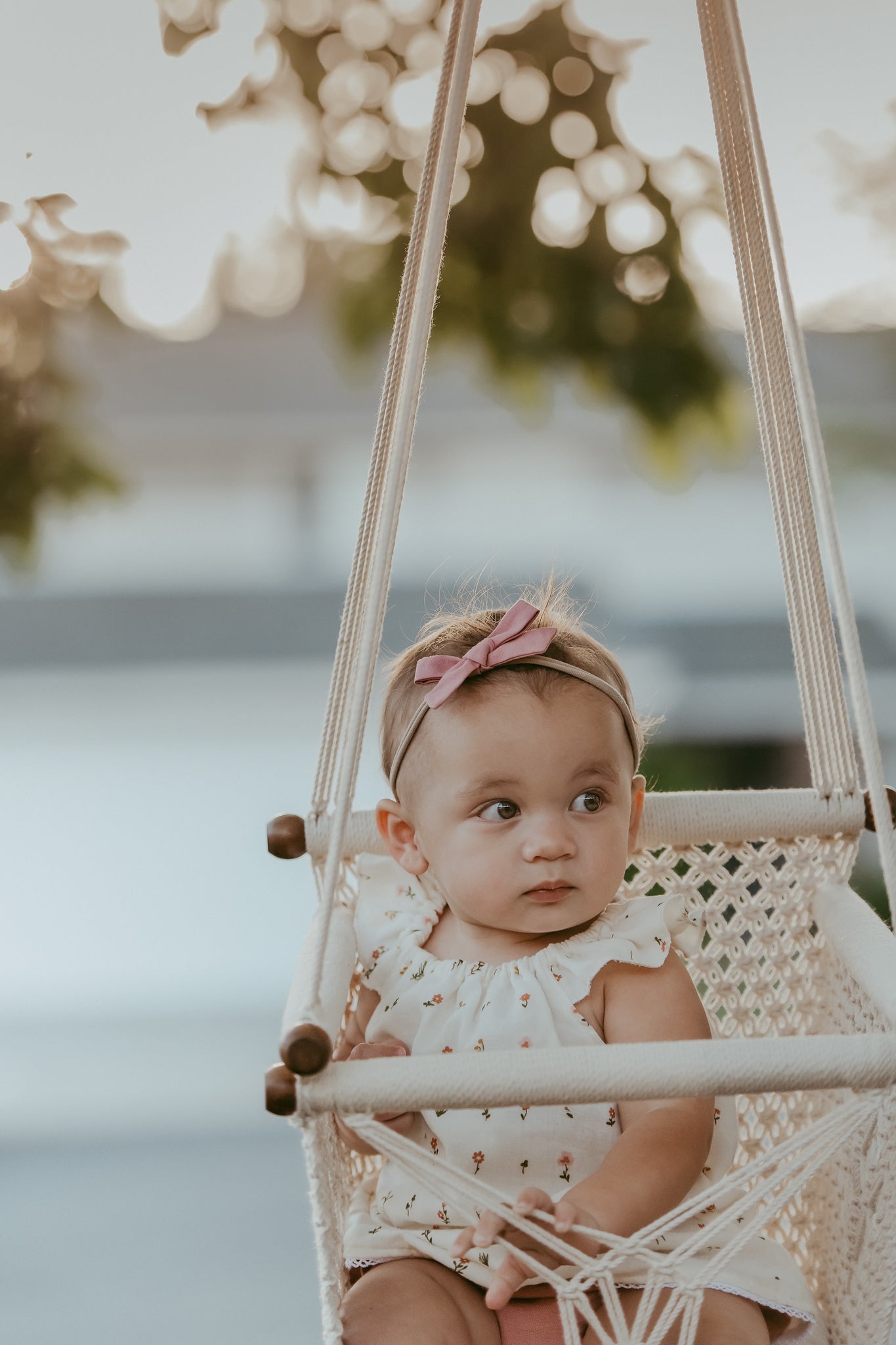 close-up of a baby sitting on a macrame swing chair