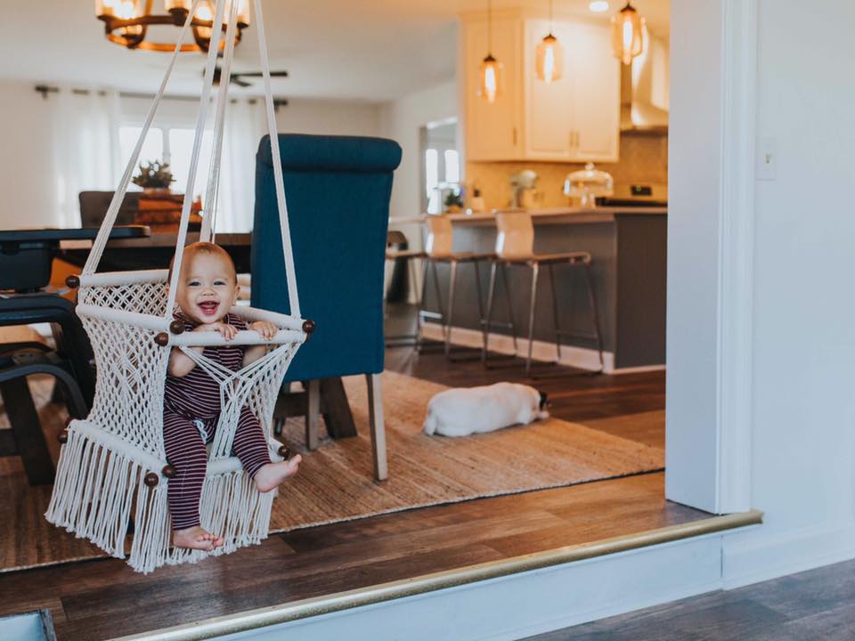 baby swing chair in cream - style picture with baby at home - angle view
