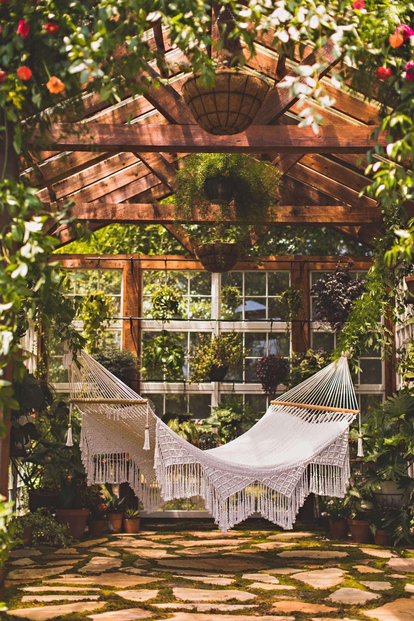 Comfortable handwoven outdoor macrame hammock on porch with natural cotton ropes and wooden spreader bars