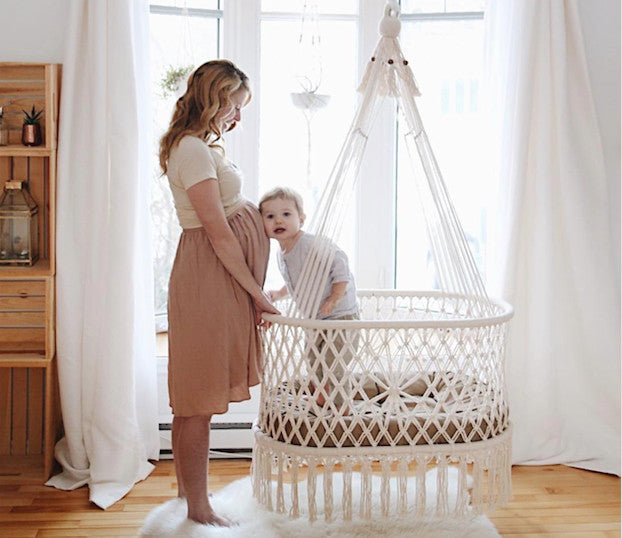 hanging cradle (hanging bassinet) with a baby inside