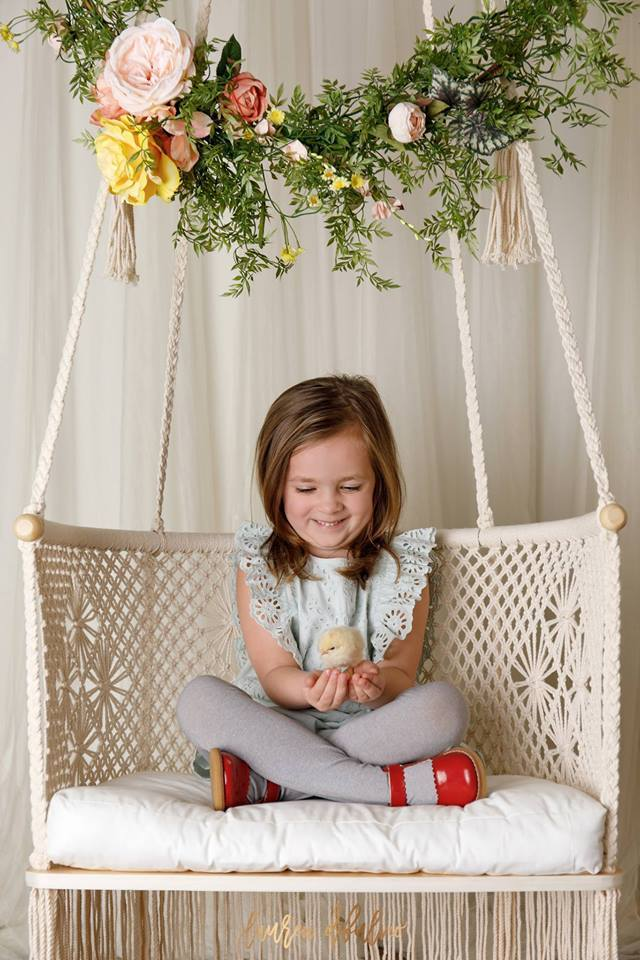 hangng chair with a kid sitting on with a baby duck