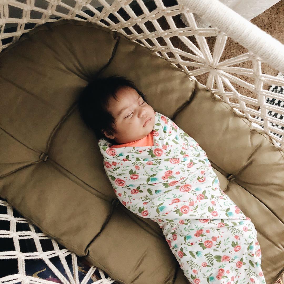 newborn sleeping into a hanging crib