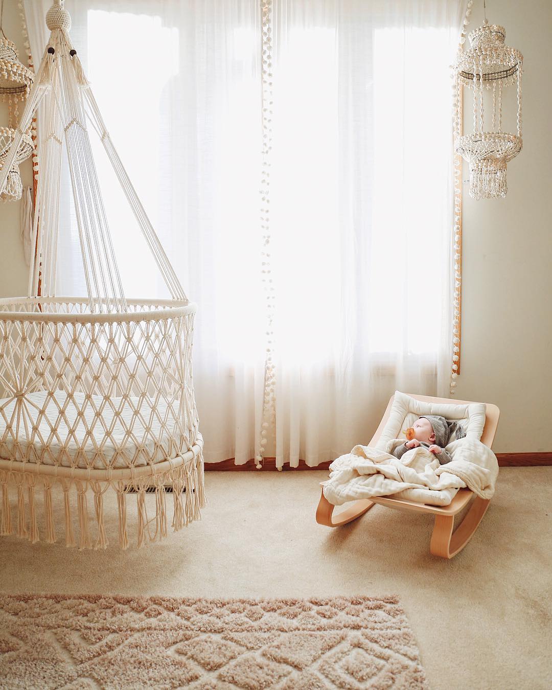 baby rocking chair next to a hanging cradle