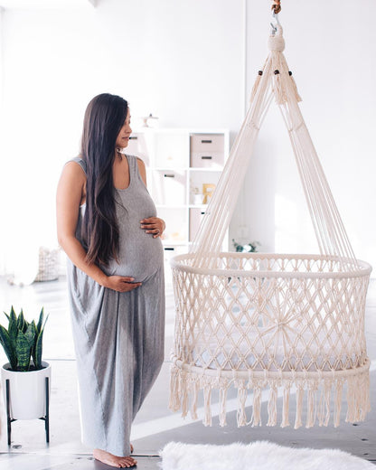 expectant mother next to a hanging bassinet