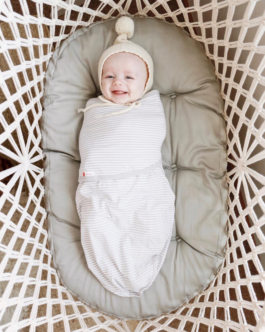 baby smiling in a hanging bassinet