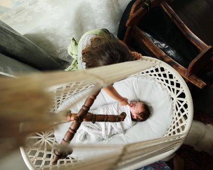 newborn sleeping in a hanging bassinet