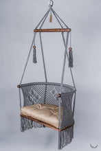 gray color hanging chair with a khaki color cushion