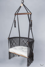 black color hanging chair with a ivory color cushion