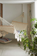 indoor handwoven hammock with plants near by