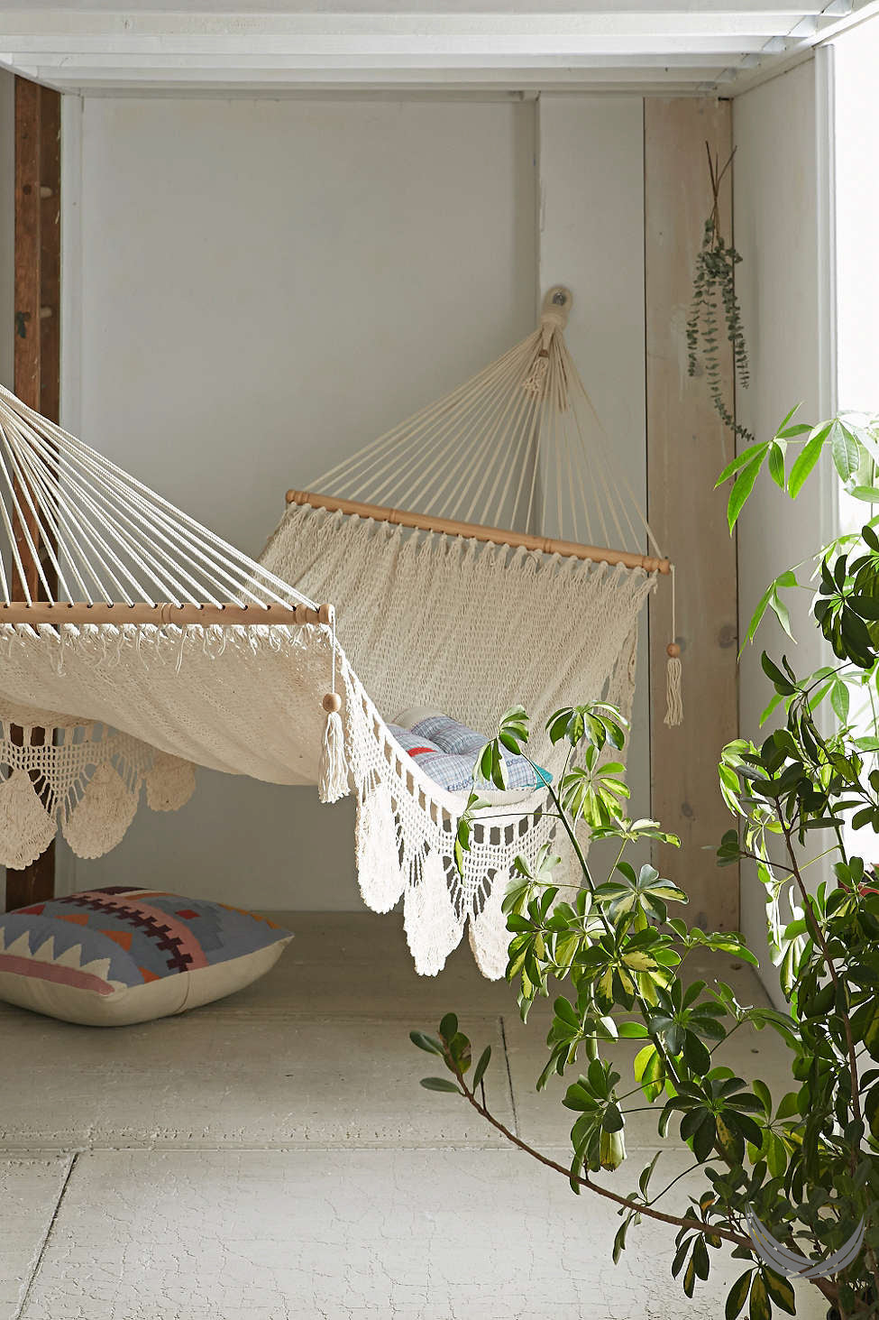 indoor handwoven hammock with plants near by